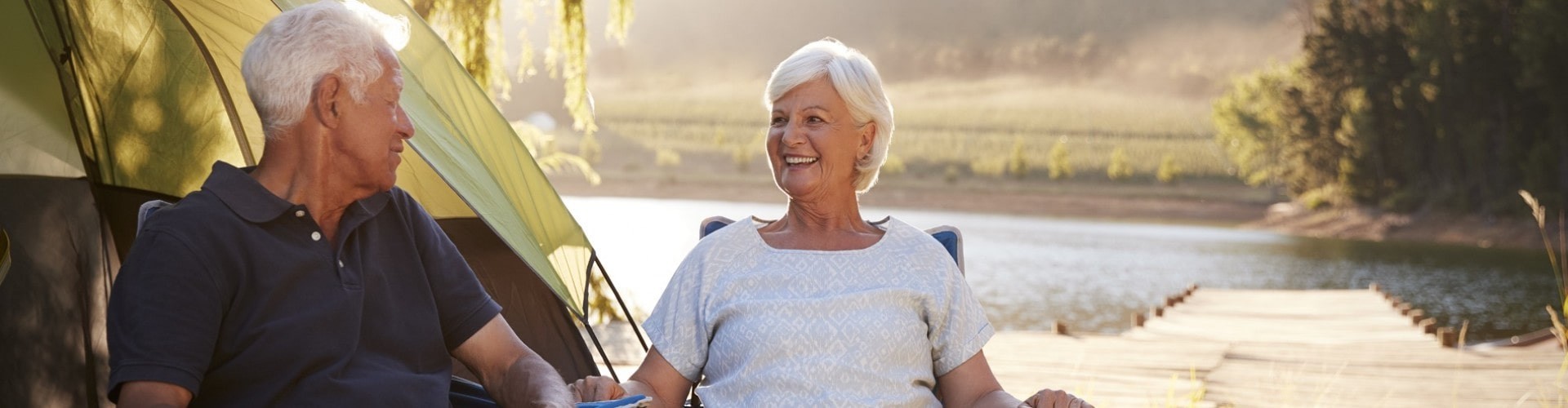 senior couple enjoying their campsite at a beautiful lake